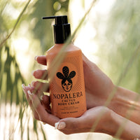 Nopalera cactus body cream Flor de Madera bottle held in hands with natural light.