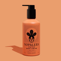 Nopalera cactus body cream bottle in Flor de Madera scent on a peach background.