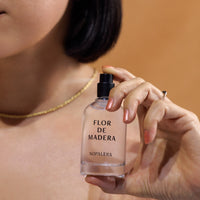 Woman holding Nopalera Luxury Mexican fragrance Flor de Madera bottle.