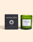 A green glass topoztlan candle with a white label that reads 'Nopalera' next to its black packaging box with the same brand name.