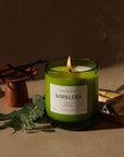Nopalera Todos Santos scented candle in green glass jar lit with incense smoke