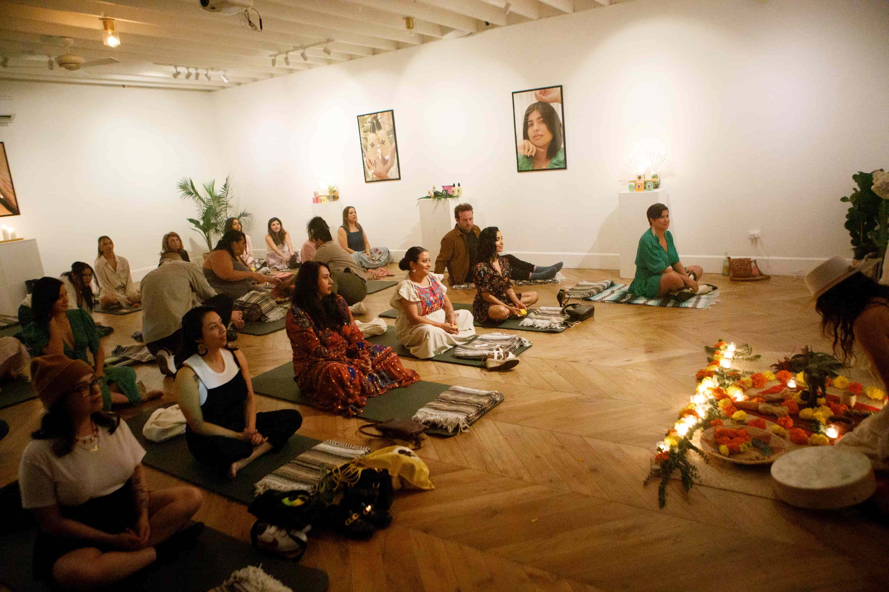 Group of people sitting on the floor in a circle in a room with white walls and wooden floors for Nopalera brand