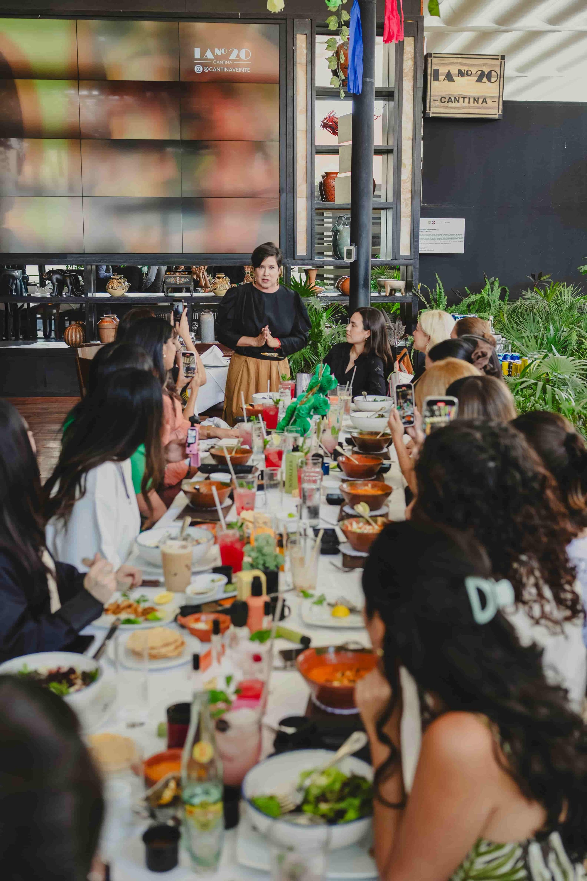 Group of people dining at a long table in a restaurant setting with Sandra Velasquez for Nopalera brand