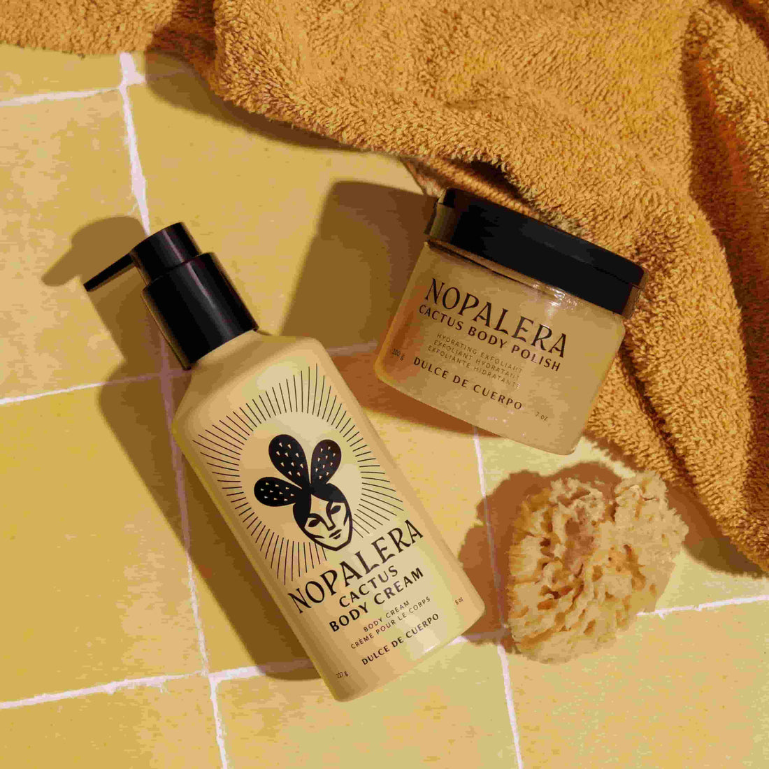 Nopalera body care products on a yellow tiled floor with a towel and sponge.