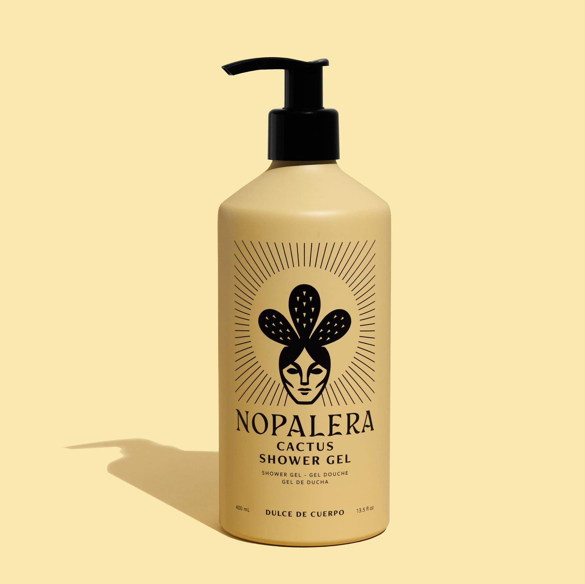 A beige pump bottle of Nopalera Cactus Shower Gel with a black pump dispenser, set against a solid pale yellow background with a soft shadow cast to the left.