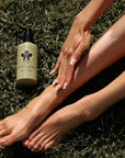 Person applying Nopalera body cream Bosque Místico to legs on grass