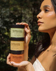 Woman holding Nopalera body polish in a natural setting