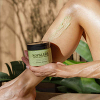 Person applying Nopalera body polish to their leg with a natural background