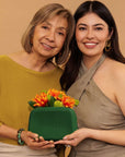 Mother's day Nopalera gift with purchase. A Green Nopalera cosmetic pouch with gold zipper and embossed logo.