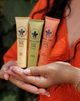 Three Nopalera cactus hand cream tubes held in a person's hands with a blurred background.