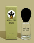A glass bottle of Luxury Mexican fragrance Bosque Místico perfume with a black cap, next to its green packaging box with a floral illustration and the brand name 'Nopalera'.