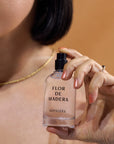 Woman holding Nopalera Luxury Mexican fragrance Flor de Madera bottle.