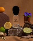Nopalera Flor de Madera Luxury Mexican  perfume bottle surrounded by citrus fruits, flowers, and wood elements representing the fragrance notes