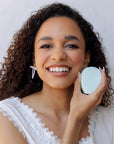 Woman holding a Nopalera shampoo bar with a white background