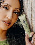 Woman holding a tube of nopalera cactus hand cream bosque místico 