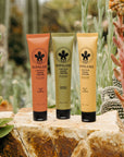 Three tubes of Nopalera cactus hand cream on a rock with a cactus background