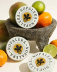 Nopalera citrus lotion bars displayed with oranges, lime, and tropical fruits.