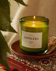 Nopalera Mérida scented candle in green glass jar lit on decorative tray