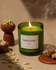 lit Nopalera Mérida scented candle in green glass jar with incense smoke and resin
