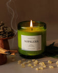 Nopalera scented Tepoztlan candle in green glass jar lit with incense beside it