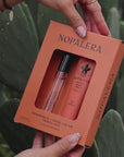 Person applying Nopalera cactus hand cream moisturizer in Flor de Madera scent with cactus plants in the background